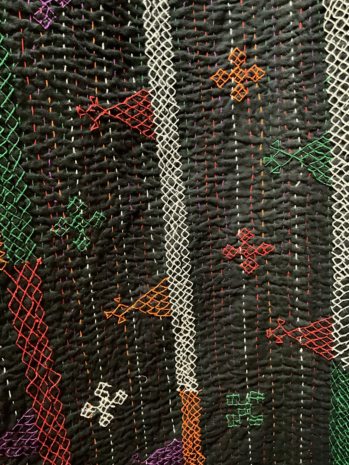 Hand stitched quilt in black with multi coloured embroidery