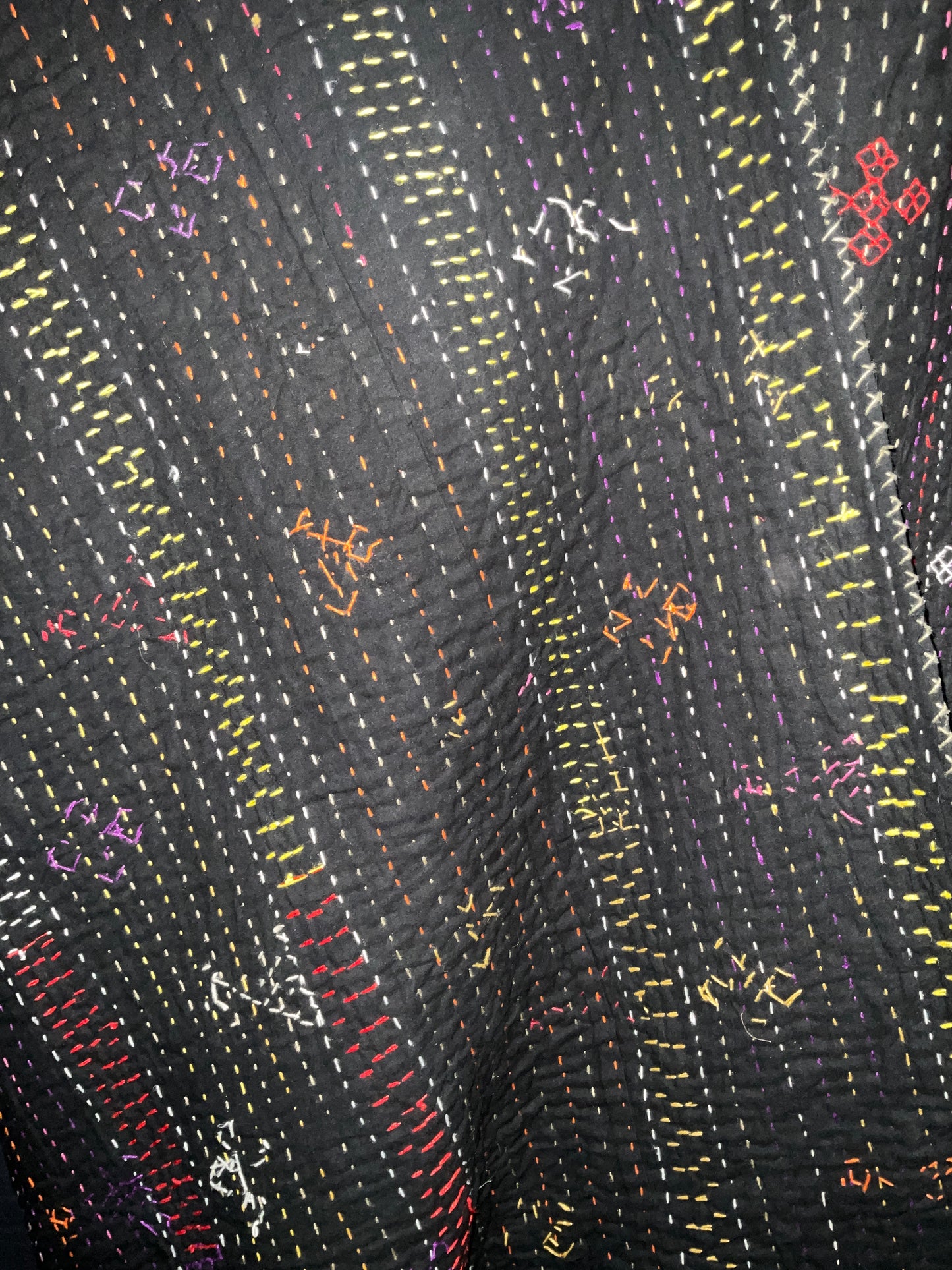 Hand stitched quilt in black with multi coloured embroidery